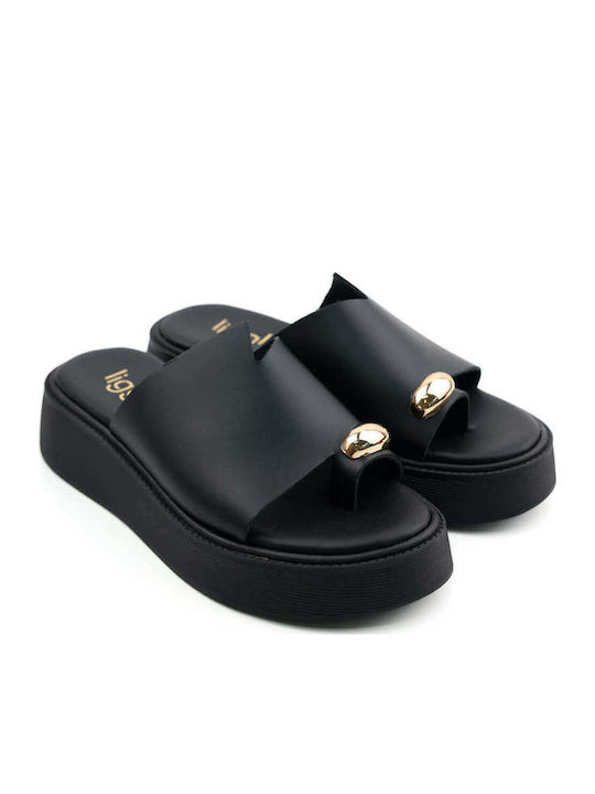 Schwarze Flatforms Goldenelement am Zeh